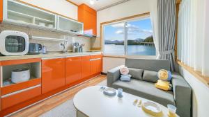 a living room with a couch and a kitchen at Chuncheon El Dorado Kid's Pension in Gapyeong