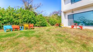 un groupe de bancs colorés assis à l'extérieur d'un bâtiment dans l'établissement Jeju Damongchae Pension, à Jeju