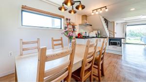 une cuisine avec une table et des chaises dans une cuisine dans l'établissement Jeju Damongchae Pension, à Jeju