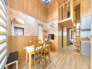 a kitchen with wooden walls and a table and chairs at Diorem Pension in Jeju +15 photos