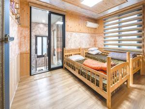 a bedroom with two bunk beds and a window at Diorem Pension in Jeju
