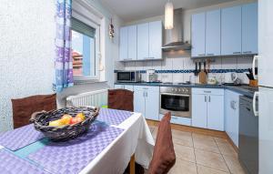 a kitchen with a table with a bowl of fruit on it at Beautiful Apartment In Barbariga in Barbariga