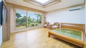 a large room with a bed and a table at jeju oceancliffcottage in Jeju