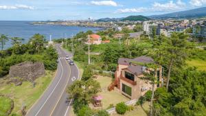a house on a hill next to a road at jeju oceancliffcottage in Jeju