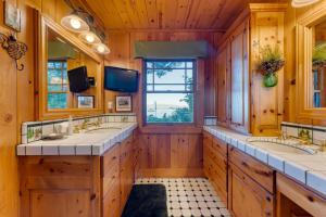ein Bad mit 2 Waschbecken und einem TV in der Unterkunft Homewood Lakefront by AvantStay Private Beach Lake Access Views in Homewood + 47 Fotos