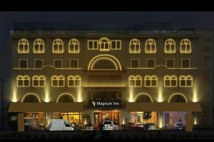 拉合尔Magnum Inn的一座前面有招牌的大楼
