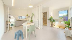 a kitchen and living room with a white table and chairs at gyeongju daol dokchae pension in Gyeongju