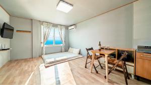 a room with a table and chairs and a window at Ganghwa Haemolupension in Incheon