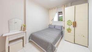 una piccola camera da letto con un letto e uno specchio di gapyeong hanulteo pension a Gapyeong