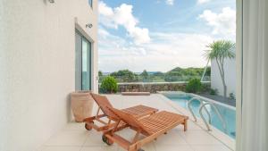 a patio with a bench and a swimming pool at Jeju stay eden Dokche poolvila Pension in Seogwipo