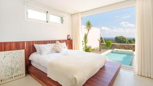 a bedroom with a bed and a swimming pool at Jeju stay eden Dokche poolvila Pension in Seogwipo
