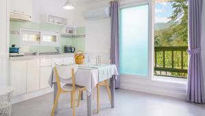 a kitchen with a table and chairs and a window at yangpyeong beulleosseom pet spa pension in Yangpyeong