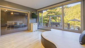 a bedroom with a large window and a table with chairs at Hongcheon inmylife dokche pension in Hongcheon