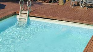 a chair in a swimming pool next to a wooden deck at Hongcheon inmylife dokche pension in Hongcheon +12 photos