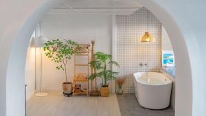 a bathroom with a white tub and potted plants at gyeongju planb pet pension in Gyeongju +9 photos
