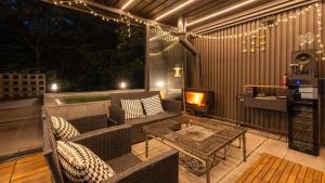 a patio with a couch and a table and lights at gwangju chez pompom dokchae poolvilla in Gwangju +1 photo