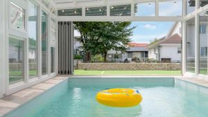 a large swimming pool with a yellow rubber boat in it at daebudo uramstay pension in Ansan