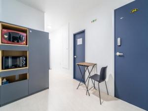 a room with a blue door and a table and a stool at Jeju moons stay in Jeju