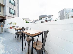 a row of tables and chairs on a balcony at Jeju moons stay in Jeju