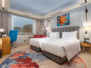 Postel nebo postele na pokoji v ubytování Ramada Encore by Wyndham Rajbagh Srinagar + 29 fotografií
