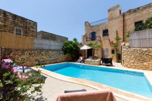 a swimming pool in a courtyard with a building at Ta'Peppa in Xagħra