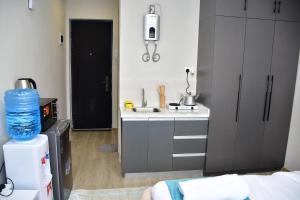 a small kitchen with a sink and a stove at Haydenco Suites Furnished Studios in Nairobi