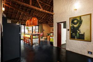 a dining room with a table and a painting on the wall at Kudisai Marayoor - Munnar in Munnar