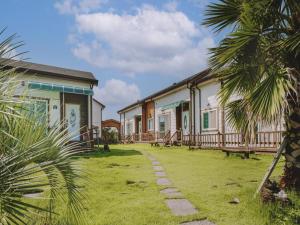 a group of buildings with palm trees in the foreground at Jeju Kkumkkuneun Jeju Pension in Seogwipo +8 photos