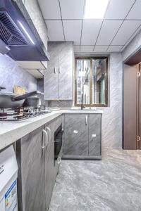 a kitchen with stainless steel cabinets and a stove at 上海柠檬汁民宿 Shanghai lemon juic B&B-Shanghai Lemon Deluxe Room 外滩南京西路步行街 in Shanghai
