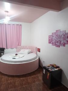 una camera da letto con un grande letto con una tenda rosa di Hotel canal hum samambaia a Brasilia