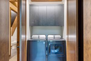 una piccola lavanderia con lavatrice e asciugatrice di Lazy River Glamp-House by AvantStay Newly Built Luxe Indoor-Outdoor Living a La Pine