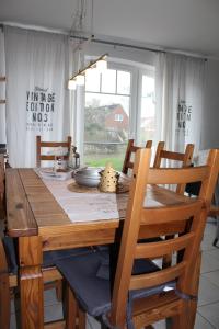 comedor con mesa de madera y sillas en Das GrachtenDOMiZiL Greetsiel, en Greetsiel