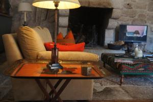 a living room with a couch and a table with a lamp at Casa de Sezim in Guimarães