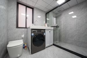 a bathroom with a washing machine and a shower at 上海柠檬汁民宿 Shanghai lemon juic B&B-Shanghai Lemon Deluxe Room 外滩南京西路步行街 in Shanghai