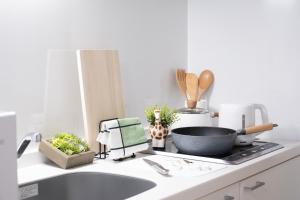 a kitchen counter with a sink and a pan on a stove at The Peak Tengachaya in Osaka