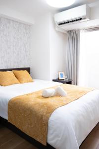 a bedroom with two beds and a air conditioner at The Peak Tengachaya in Osaka