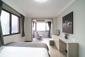 a white bedroom with a bed and a desk at 上海柠檬汁民宿 Shanghai lemon juic B&B-Shanghai Lemon Deluxe Room 外滩南京西路步行街 in Shanghai