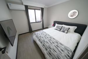 a bedroom with a bed with a black and white comforter at 上海柠檬汁民宿 Shanghai lemon juic B&B-Shanghai Lemon Deluxe Room 外滩南京西路步行街 in Shanghai