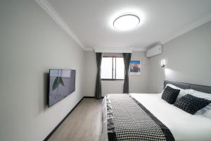 a bedroom with a bed and a tv on a wall at 上海柠檬汁民宿 Shanghai lemon juic B&B-Shanghai Lemon Deluxe Room 外滩南京西路步行街 in Shanghai