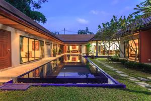 ein Haus mit einem Teich im Hof in der Unterkunft Frangipani pool villa - garden, BBQ & maid in Nai Harn Beach