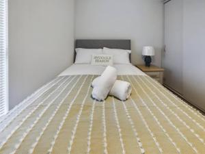 a bed with two pillows on it in a bedroom at Trendy 2-Bedroom Belfast Apartment in Belfast
