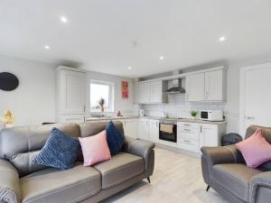 a living room with a couch and a kitchen at Trendy 2-Bedroom Belfast Apartment in Belfast