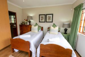 two twin beds in a room with a window at Chikanka in Himeville +19 photos