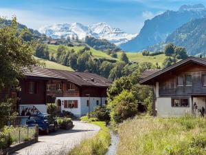 a winding road in a village with mountains in the background at Hidden Retreats 1466 Edition in Reichenbach
