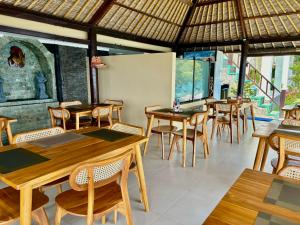 a dining room with wooden tables and chairs at Amed Santorini Villa in Amed