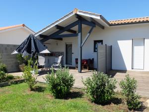 a patio with an umbrellas in front of a house at Chambre No1 Lit double in Saint-Julien-en-Born
