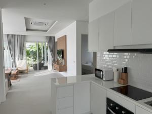 a kitchen with white appliances and a living room at Luxury villa Kamala Garden View by Lofty in Kamala Beach