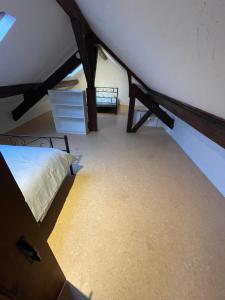 a attic room with a bed and a dresser at Appartement 3 chambres climatisé 100m2 in Chaussin