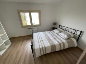 a bedroom with a bed and a window at Appartement 3 chambres climatisé 100m2 in Chaussin