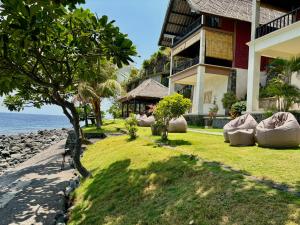 a house on the beach next to the ocean at Amed Santorini Villa in Amed